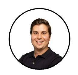 Doctor Zac De Gooyer head shot. Doctor De Gooyer is wearing a black shirt and smiling.